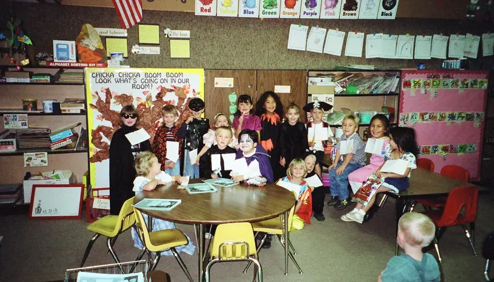 Gathered around classroom tables · 1998